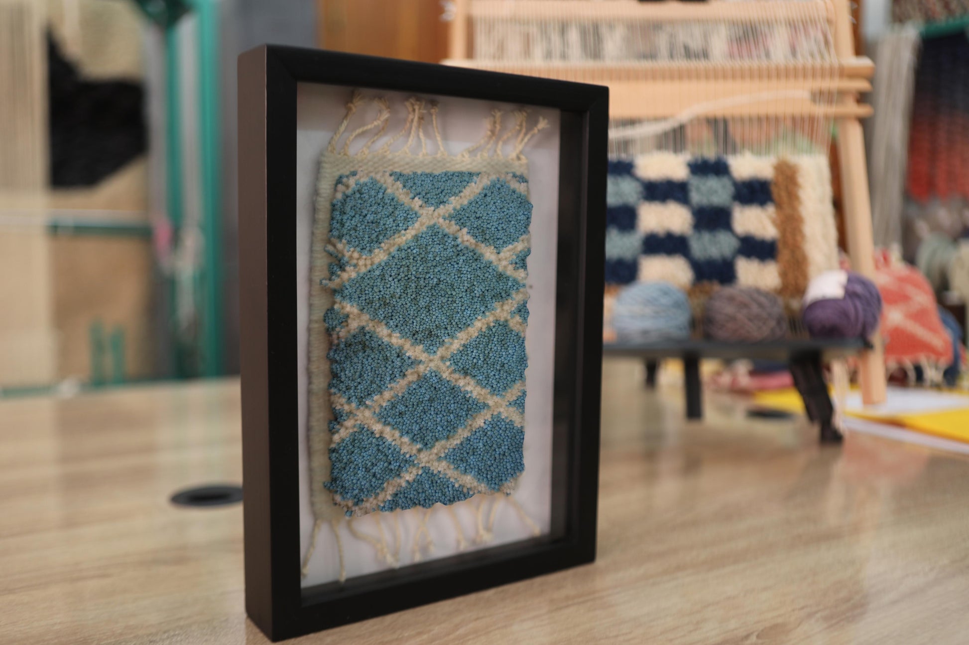 blue diamond grid moroccan rug, framed mini moroccan rug art, wool moroccan wall hanging, knot by knot mini tapestry, moroccan textile wall decor, hand-knotted moroccan wool rug, small geometric moroccan rug, boho framed rug, artisan moroccan woven art, wall art mini moroccan carpet
