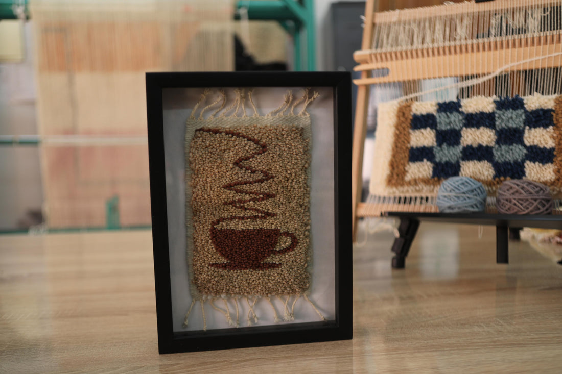 Hand-knotted Moroccan rug wall art (25x31 cm) featuring a cozy coffee cup design. A framed wool tapestry perfect for kitchens, cafés, or minimalist spaces.
