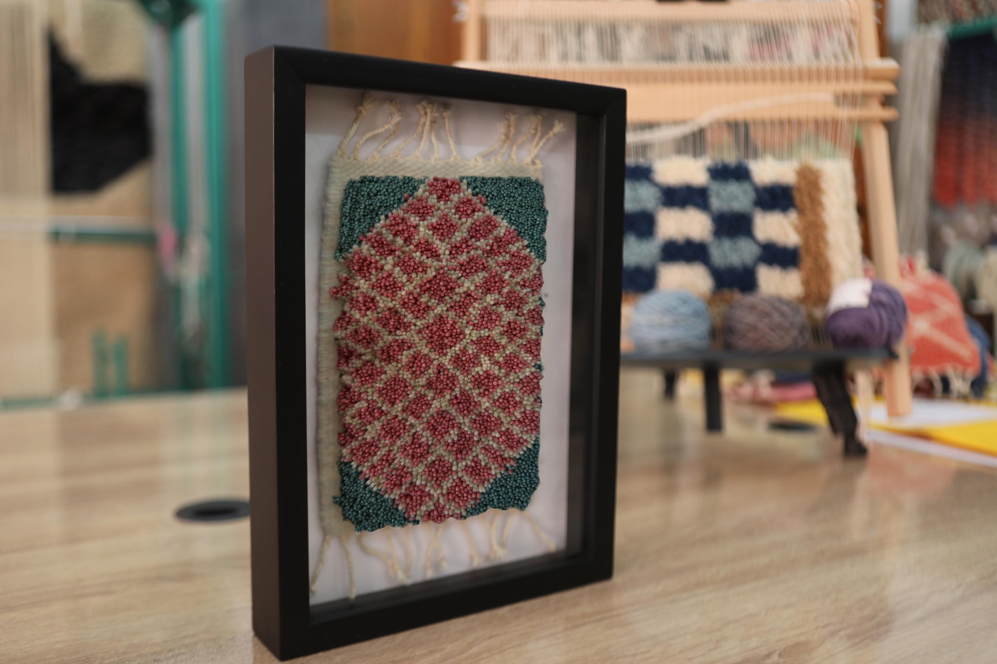 moroccan rug, diamond pattern rug, framed wool rug, hand knotted moroccan tapestry, red and green rug wall art, artisan moroccan weaving, knot by knot wall decor, small moroccan rug art, geometric wool textile
