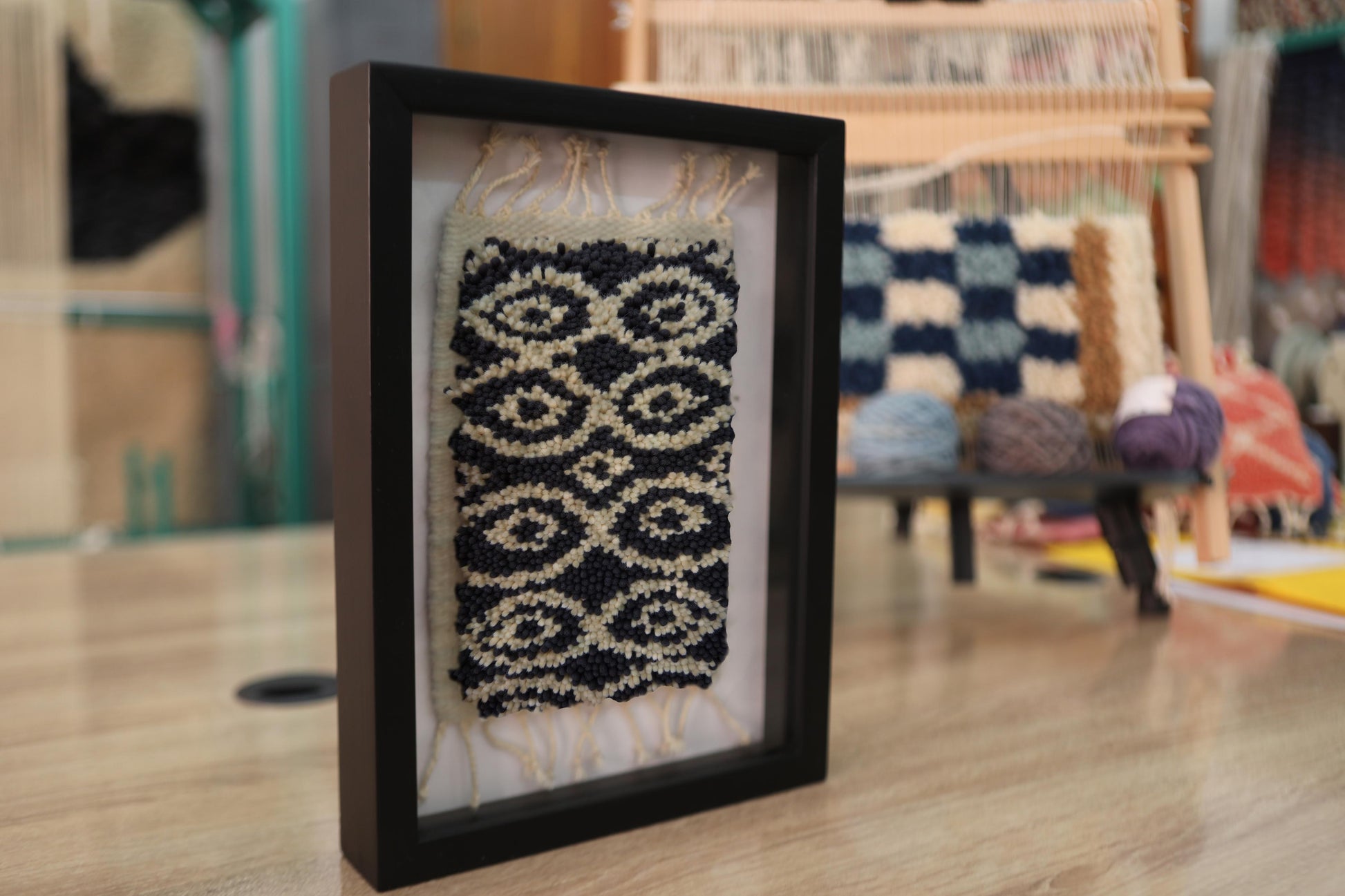 moroccan rug, hand-knotted rug, eye pattern rug, black and beige wool, mini wall rug, artisan framed rug, tribal moroccan textile, knot by knot weaving, wool wall art, boho decor, framed moroccan rug
