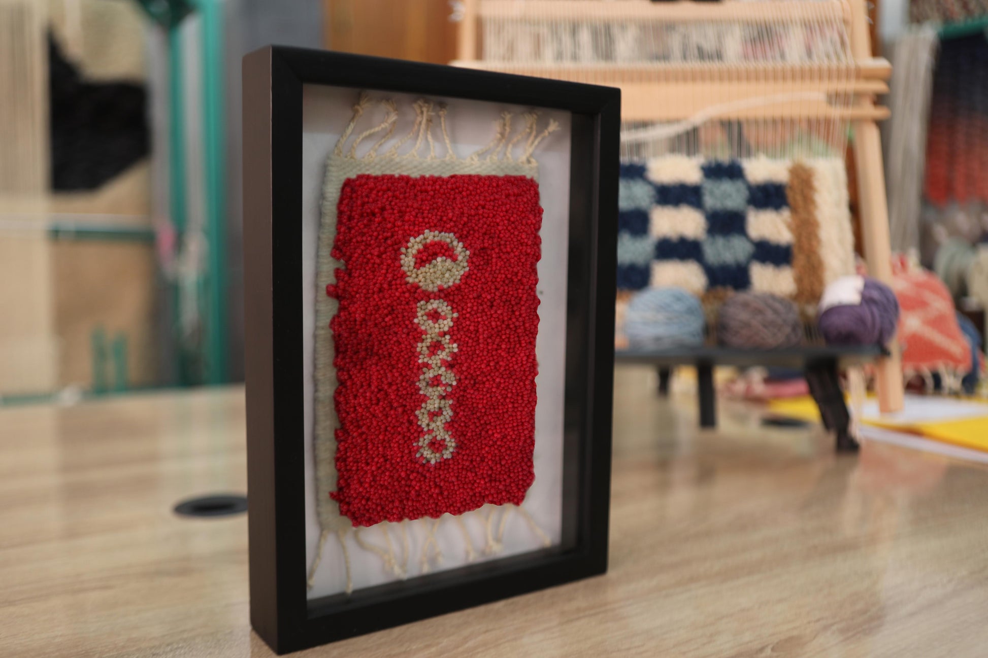 moroccan rug, hand-knotted wool rug, symbolic motif rug, vertical pattern red rug, framed moroccan wall art, tribal berber rug miniature, knot by knot rug weaving, artisan wool framed textile, boho decor wall hanging, moroccan wool weaving
