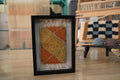 moroccan rug diamond pattern, geometric wool wall art, hand knotted mini rug, framed moroccan textile, orange and yellow moroccan art, boho rug wall hanging, artisan moroccan wool tapestry, knot by knot moroccan rug, earthy home decor, 25x31 cm framed rug
