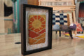 moroccan rug sun design, sunrise rug wall art, desert landscape textile, framed wool moroccan mini rug, boho sun pattern decor, handmade moroccan wool art, knot by knot rug, artisan moroccan wall hanging, earthy wool tapestry, 25x31 cm moroccan framed rug
