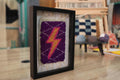 moroccan rug wall art, gradient lightning bolt textile, framed wool mini rug, hand-knotted lightning decor, pink orange yellow bolt art, purple wool tapestry, knot by knot wall hanging, moroccan lightning rug
