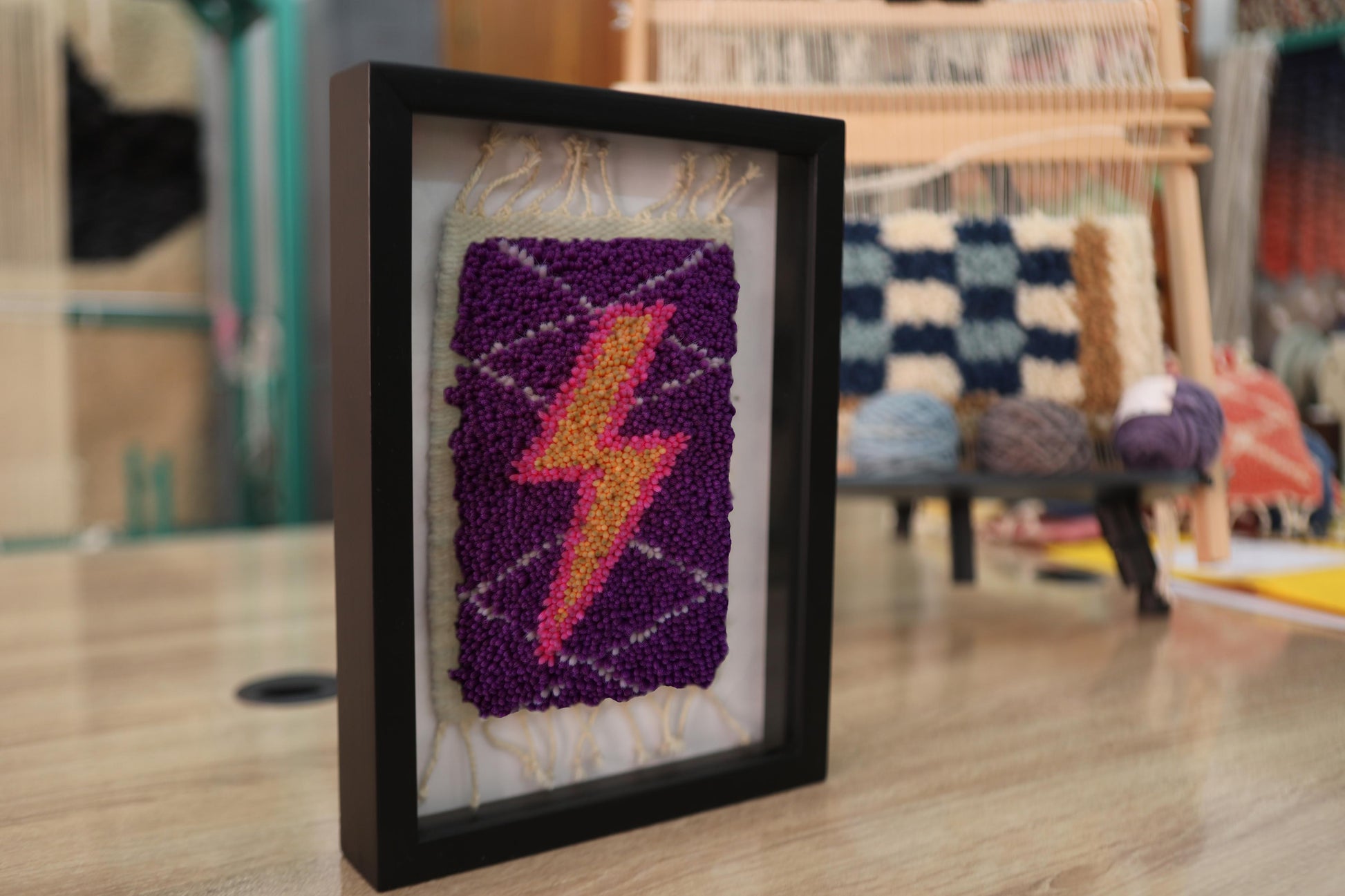 moroccan rug wall art, gradient lightning bolt textile, framed wool mini rug, hand-knotted lightning decor, pink orange yellow bolt art, purple wool tapestry, knot by knot wall hanging, moroccan lightning rug
