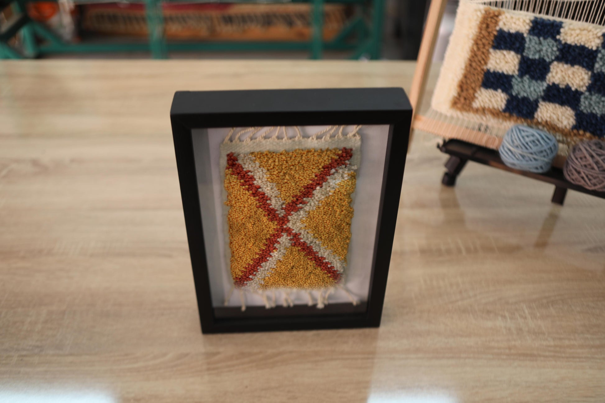 moroccan rug wall art, hand knotted moroccan tapestry, framed mini moroccan rug, mustard yellow x pattern rug, tribal wool wall art, small boho textile decor, knot by knot moroccan weaving, 25x31 cm framed rug, handmade wool art, artisan home accent
