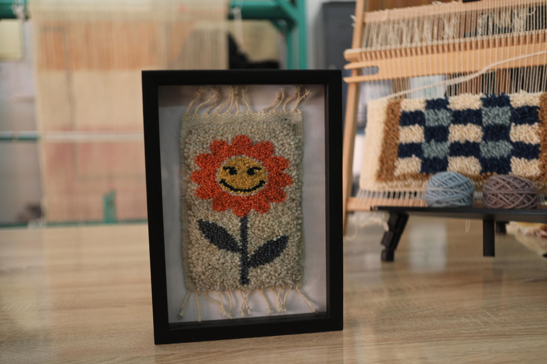 orange flower rug, moroccan rug wall art, hand-knotted wool tapestry, smiling flower textile, framed wool wall decor, mini moroccan rug, boho wool wall hanging, cheerful flower rug art, 25x31 cm framed textile, knot by knot rug design
