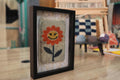 orange flower rug, moroccan rug wall art, hand-knotted wool tapestry, smiling flower textile, framed wool wall decor, mini moroccan rug, boho wool wall hanging, cheerful flower rug art, 25x31 cm framed textile, knot by knot rug design

