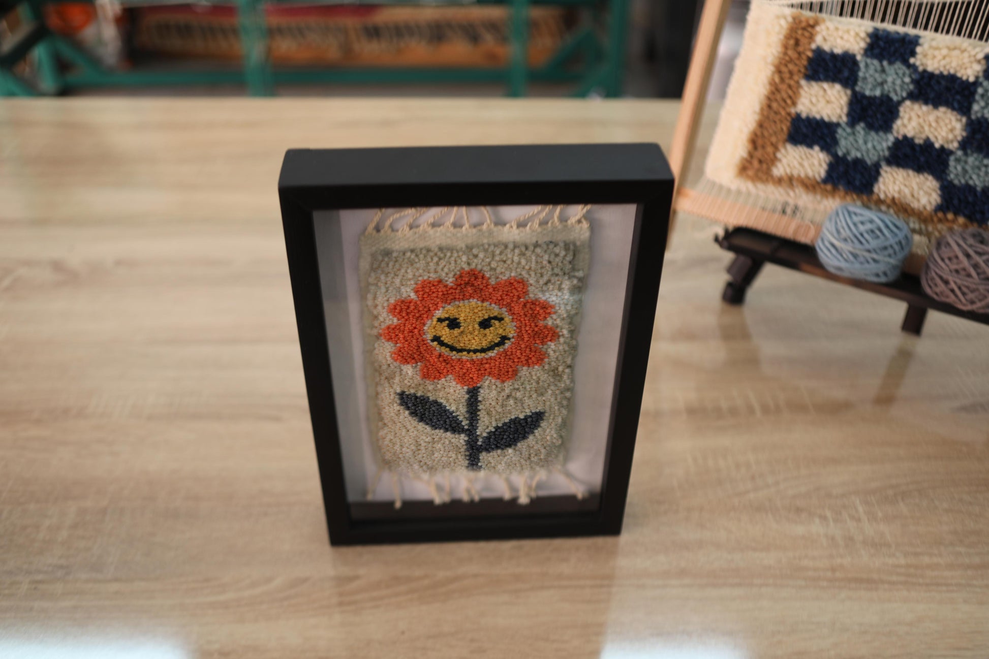 orange flower rug, moroccan rug wall art, hand-knotted wool tapestry, smiling flower textile, framed wool wall decor, mini moroccan rug, boho wool wall hanging, cheerful flower rug art, 25x31 cm framed textile, knot by knot rug design
