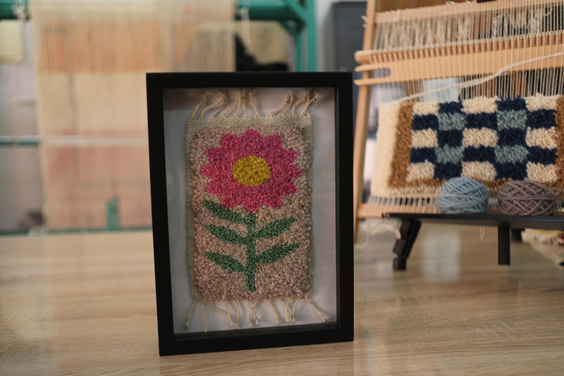 pink flower rug, moroccan rug wall art, hand-knotted wool textile, framed mini rug, boho flower wall decor, cheerful wool wall art, handmade pink flower rug, 25x31 cm wool tapestry, knot by knot rug art, smiling floral rug design
