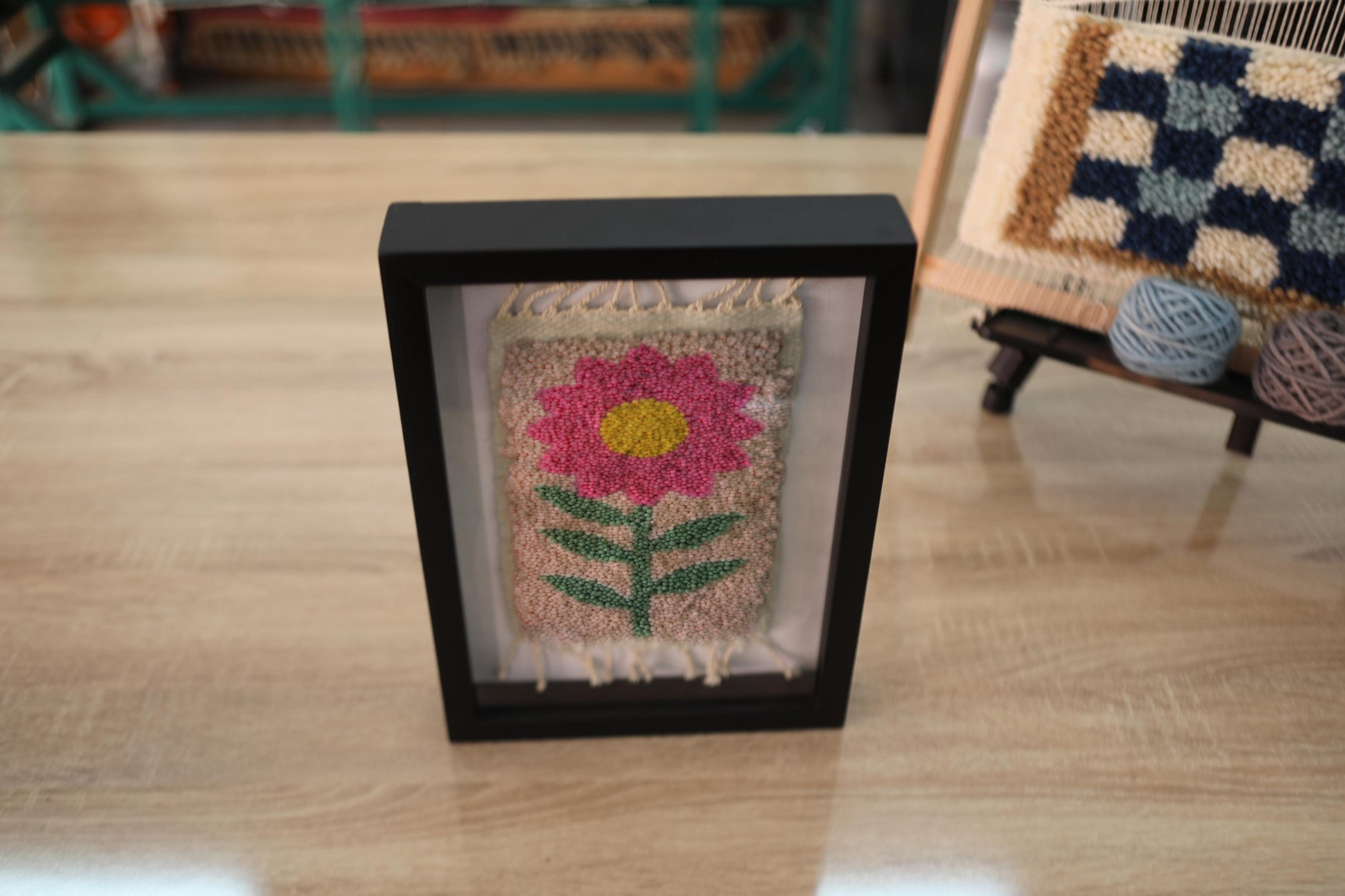 pink flower rug, moroccan rug wall art, hand-knotted wool textile, framed mini rug, boho flower wall decor, cheerful wool wall art, handmade pink flower rug, 25x31 cm wool tapestry, knot by knot rug art, smiling floral rug design
