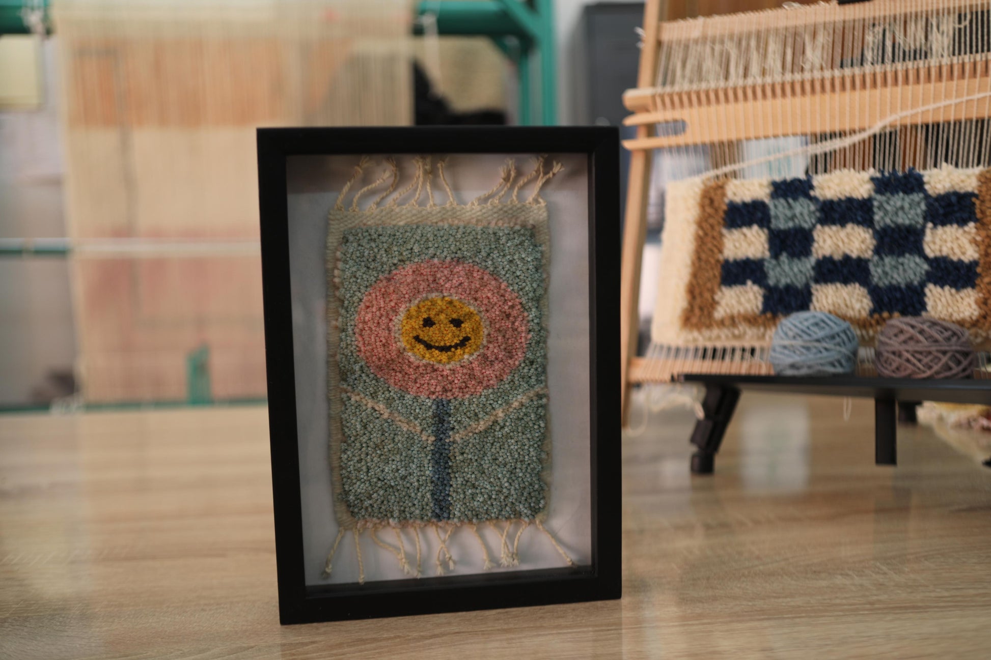 smiling flower rug, moroccan rug wall art, hand-knotted mini wool tapestry, happy flower textile decor, boho wall hanging, pink floral face rug, knot by knot moroccan rug, wool flower wall art, 25x31 cm framed rug, joyful flower textile art
