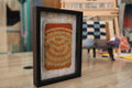 spiral moroccan rug, framed moroccan textile art, hand-knotted wool rug, boho wall decor, knot by knot rug, orange spiral wall hanging, mini moroccan rug, artisan wall piece, framed rug 25x31 cm, earthy tone moroccan rug
