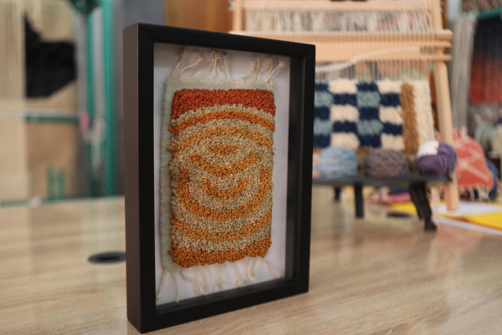 spiral moroccan rug, framed moroccan textile art, hand-knotted wool rug, boho wall decor, knot by knot rug, orange spiral wall hanging, mini moroccan rug, artisan wall piece, framed rug 25x31 cm, earthy tone moroccan rug
