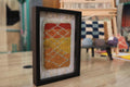sunset moroccan rug, framed moroccan wall art, diamond moroccan tapestry, boho home decor, hand knotted mini rug, warm color moroccan textile, knot by knot wool art, moroccan rug 25x31 cm, artisanal wool wall hanging, orange yellow red rug art
